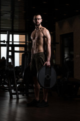 Fototapeta na wymiar Geek Bodybuilder Holding Weights In Hand