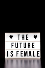 International Women's Day - concept - 'The future is female'  - light box with cinema style lettering on black background with copy space