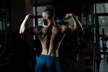 Fototapeta na wymiar Serious Bodybuilder Wearing Goggles Standing In The Gym