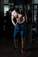 Naklejka na ściany i meble Muscular Man Flexing Muscles In Gym