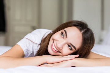 Young beauty woman lying on hands in her bed at home.