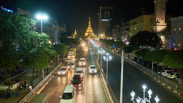 YANGON, MYANMAR - FEBRUARY 15, 2018: Evening traffic along Sule road, located in Downtown, the giant golden Sule Pagoda is seen on background, on February 15 in Yangon.