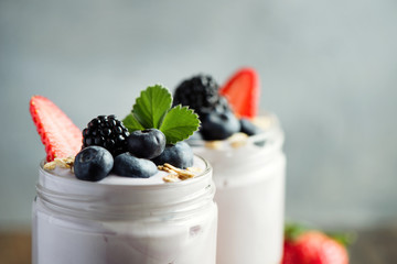 Yogurt and granola with berries, healthy cereal breakfast, toned image, selective focus