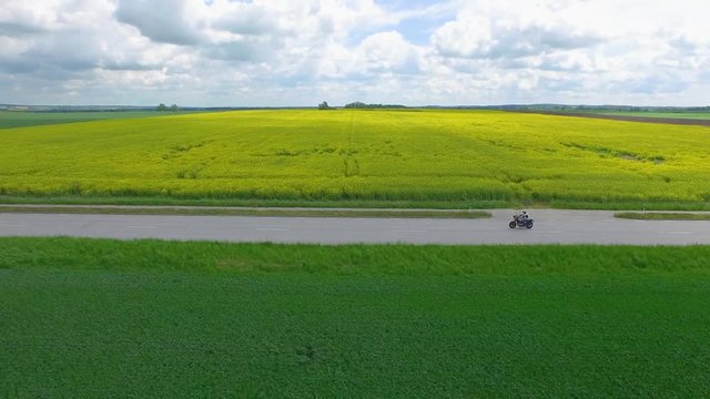 Aerial of male biker riding custom motorbike down country road