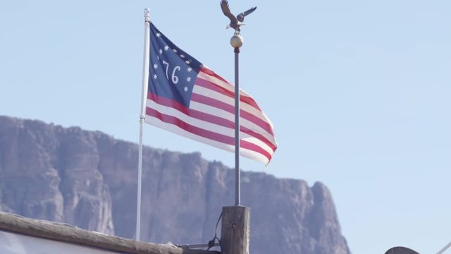 United states flag in slow motion flapping in front of western mountains