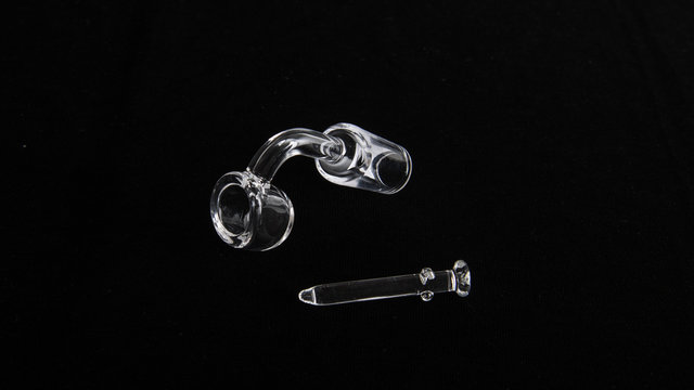 Striking Image of Quarts Nail and Quartz Banger for Marijuana on a black velvet background