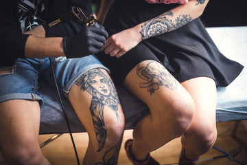 A tattoo on leg. The drawing process. Closeup. The concept of tattoo as art