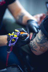 Tattoo master makes tattoo in tattoo studio. Tattoo on hand. Close up