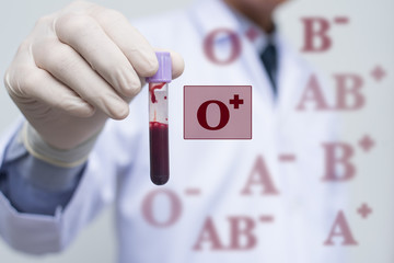 Male doctor showing whole blood in test tube and blood group icon