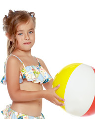 Little girl in a swimsuit with a ball