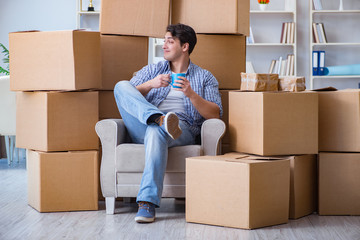 Young man moving in to new house with boxes