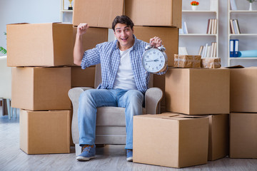 Fototapeta premium Young man moving in to new house with boxes
