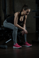 Fototapeta na wymiar Muscular Woman After Exercise Resting In Gym