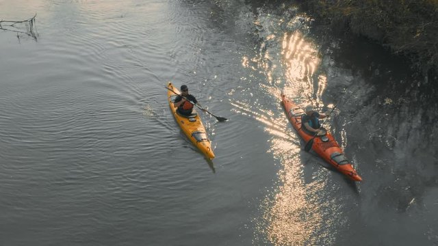 Close-up of kayakers paddling on a calm river on a beautiful sunny day.
Close-up of kayakers paddling on a calm river on a beautiful sunny day.
