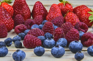Healthy mixed fruit and ingredients with strawberry, raspberry, blueberry. Berries on rustic white wooden background. Close-up. Macro image