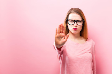 Young woman making a rejection pose on a solid background