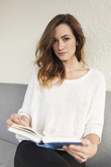 teenager girl holding a book looking into the camera