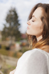 blur profile of a young women enjoying the sun with closed eyes on the balcony