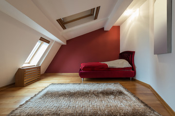 Bedroom interior in luxury red loft, attic, apartment with roof windows