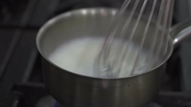Closeup chef's hands stirring coconut milk for fish soup schrimp soup in saucepan