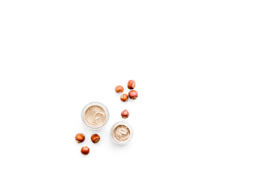 Natural cosmetics for skin care. Body scrub with hazelnut. White background top view copy space