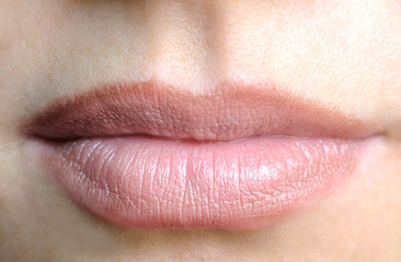 Women's lips with a nude lipstick, view front
