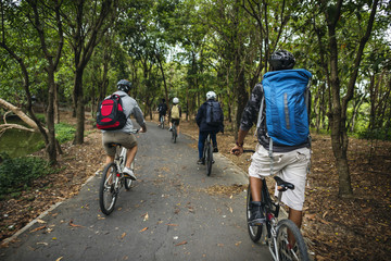 Naklejka premium Group of friends ride mountain bike in the forest together