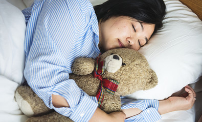 A woman in bed with a teddy bear
