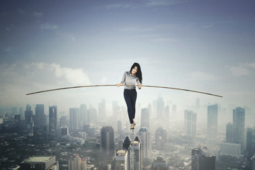 Beautiful businesswoman balancing on a rope