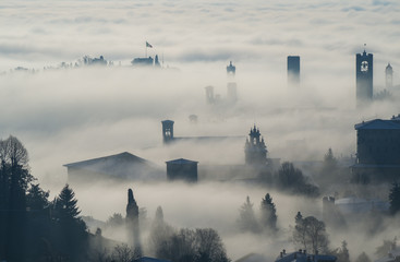 Bergamo, Italy. Drone aerial view of an amazing landscape of the fog rises from the plains and covers the old town