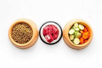 Ingredients for dry pet food. Meat and vegetables zucchini and carrot on white backgroud top view copy space