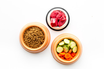 Ingredients for dry pet food. Meat and vegetables zucchini and carrot on white backgroud top view copy space