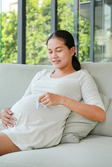 Pregnant woman holding plane model on her tummy.