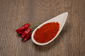 Ground and whole peppers on rustic wooden table