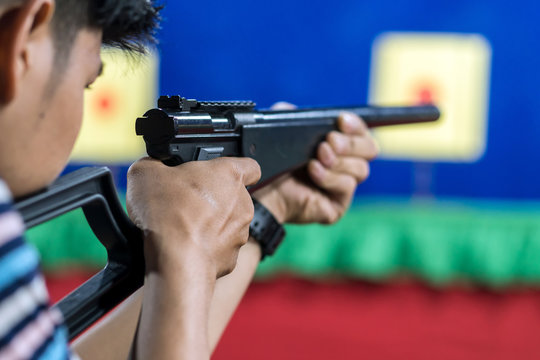 Rear view of man with his gun on shooting at the target in practice Shooting Range, sport and Soldier concept