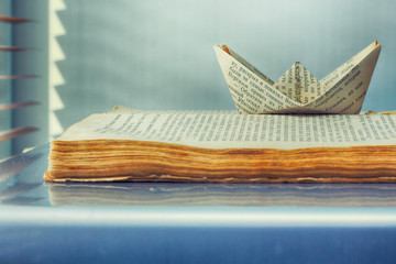 Obraz premium old book and paper ship of words