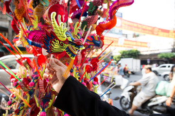 A woman pick a dragon gift for children at Yaowarat, Bangkok, Thailand