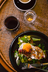 Avocado toast with egg on black plate