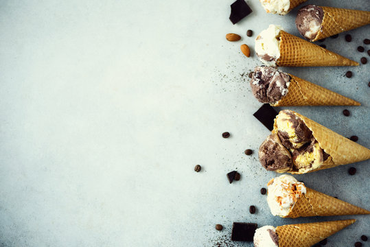 Chocolate and coffee ice cream in waffle cone with coffee beans on grey stone background. Summer food concept, copy space. Healthy gluten free ice-cream. Top view