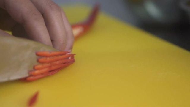 Closeup chef's hands  cutting red chili pepper