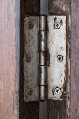 old hinge on wooden door or window, shallow depth of field