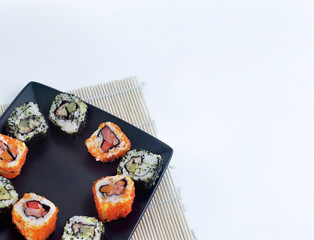 different types of Maki sushi on a black plate