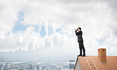 Businessman standing on roof and looking in binoculars. Mixed media