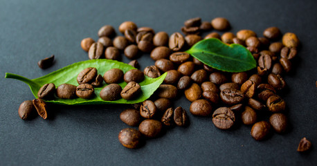 coffe beans and green leaf on black background