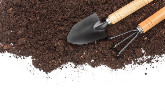 garden tools in soil isolated on white background with copy space for your text. Top view