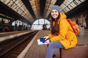 young pretty woman waiting for train at railway station. sit on © phpetrunina14