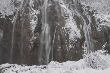 Fototapeta na wymiar Big waterfall at Plitvice Lakes National Park. Winter scenery.