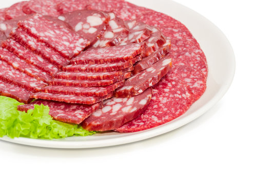 Sliced different sausages on dish closeup at selective focus