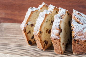 Homemade traditional chopped cupcake with raisins on the wooden background. Closeup, selective focus