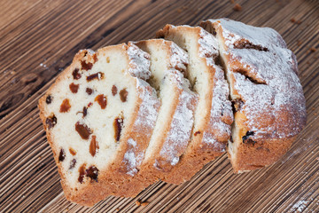 Homemade traditional chopped cupcake with raisins on the wooden background. Closeup, selective focus
